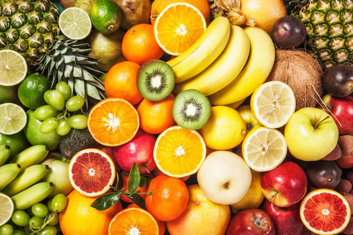 Variedade de frutas frescas, incluindo abacaxi, laranja, banana, maçã e outros, ilustrando a queda nos preços das frutas.