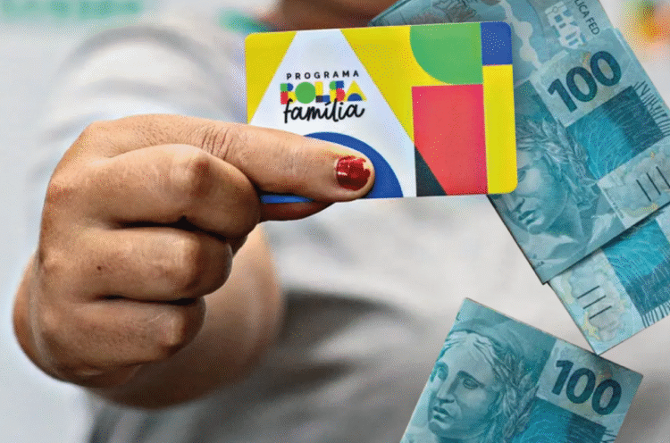 Cartão do programa Bolsa Família e notas de 100 reais, tema sobre antecipação do benefício e novas cidades na pré-lista do Governo.