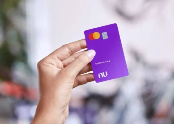Cartão Nubank roxo sendo segurado por uma pessoa, representando a personalização e os serviços oferecidos pelo banco digital.
