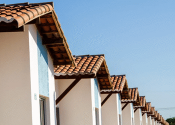Casas do programa Minha Casa Minha Vida, em uma fila de residências com telhados de cerâmica.