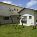 Conjunto habitacional com crianças brincando no parque em uma área residencial.