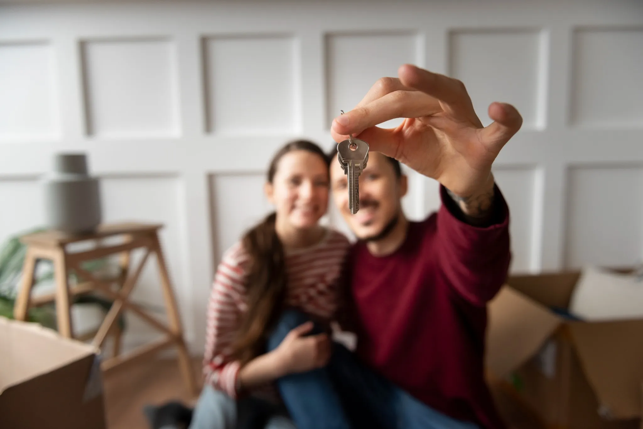 Casal feliz segurando a chave de sua nova casa, representando a inscrição no programa Aluguel Social.