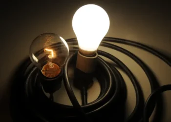 Lâmpada tradicional e lâmpada de LED iluminadas, representando a economia de energia com a Ecoenel.