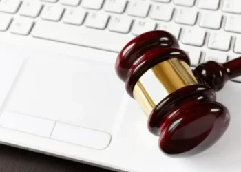 Gavel sobre teclado de laptop, representando leilão de veículos do Detran, com motos a partir de R$ 700.
