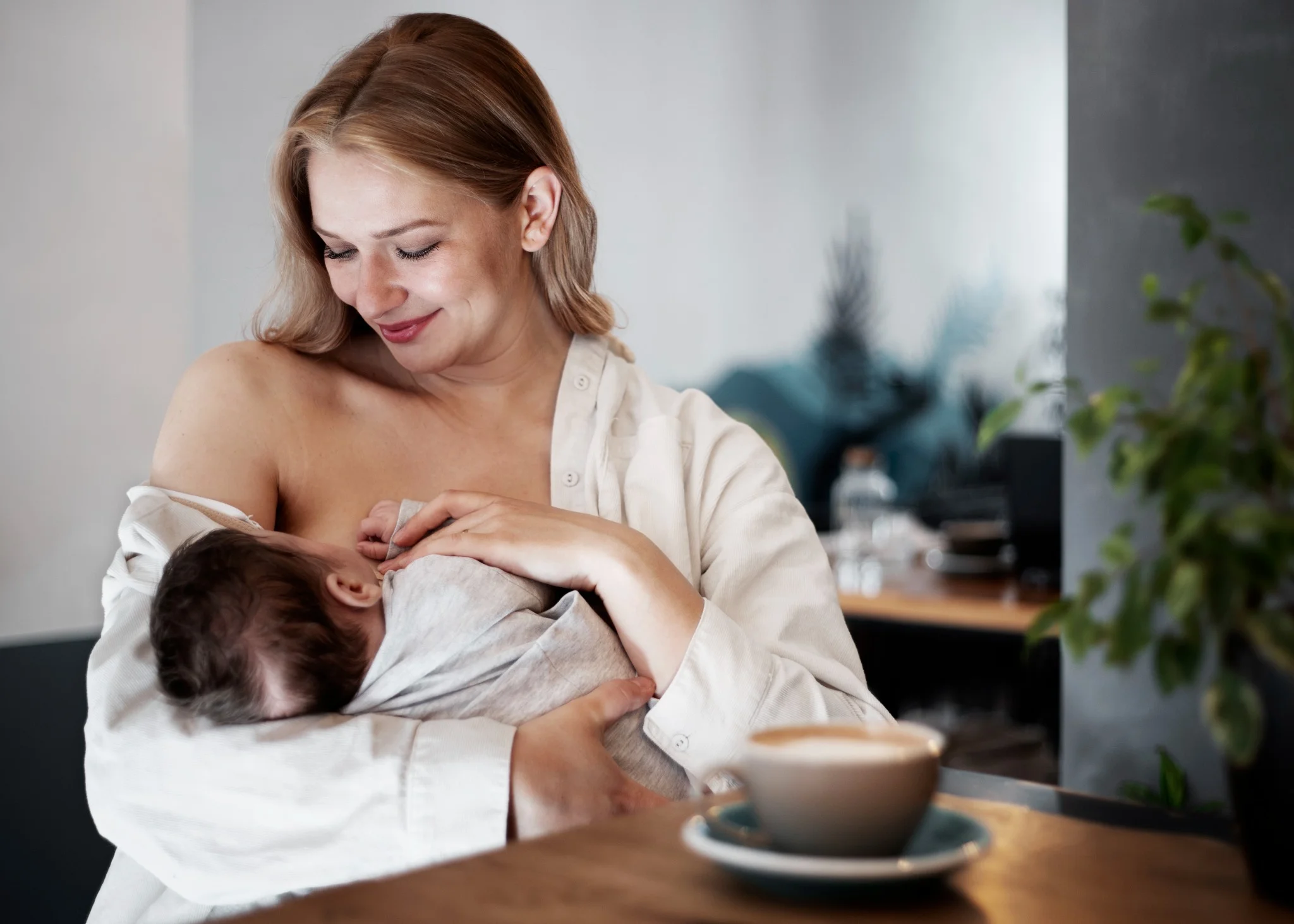 Mulher amamentando seu bebê com carinho, representando o apoio do Bolsa Família para mães lactantes.
