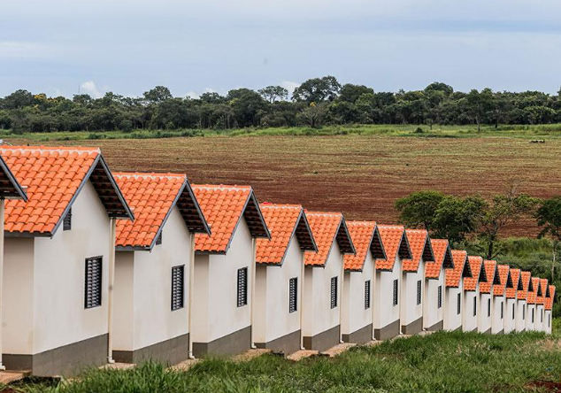 Casas do programa Minha Casa, Minha Vida com telhados vermelhos em área rural.