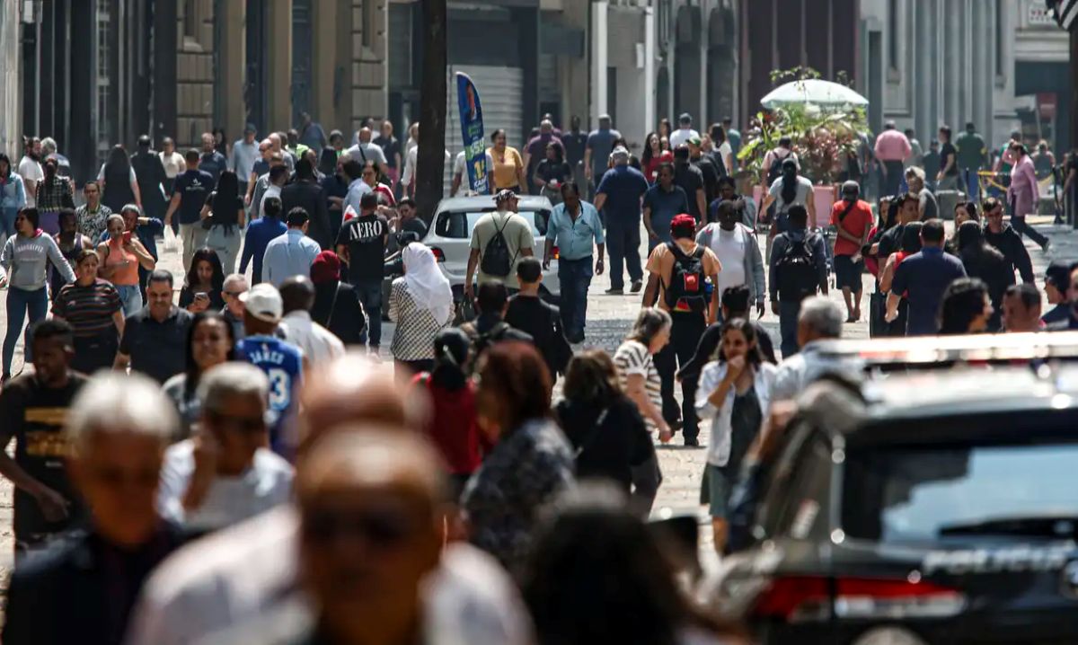 Imagem de uma rua movimentada, representando a vida cotidiana dos trabalhadores brasileiros.