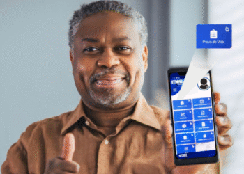 Homem sorrindo segurando um celular com a tela exibindo a opção de Prova de Vida no app Meu INSS.