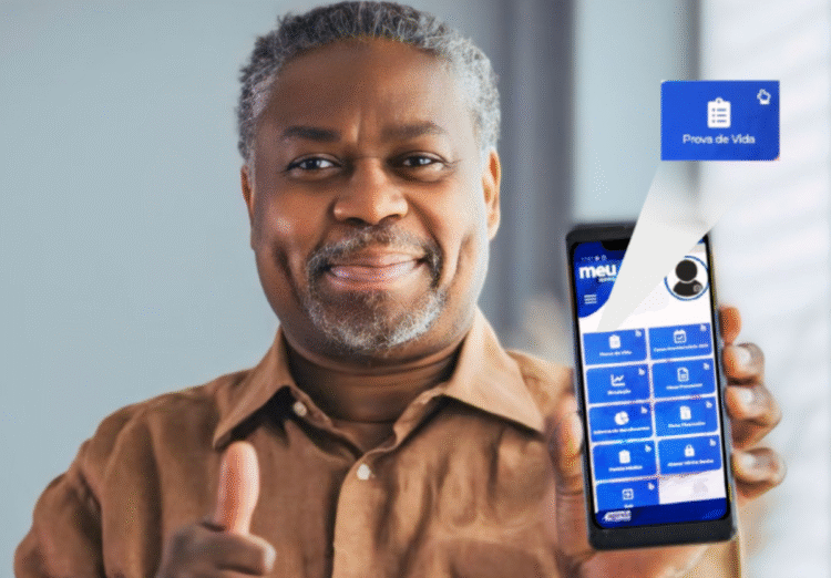 Homem sorrindo segurando um celular com a tela exibindo a opção de Prova de Vida no app Meu INSS.
