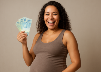 Gestante sorridente segurando dinheiro