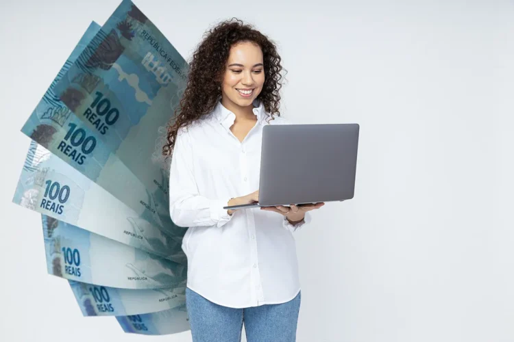 Mulher sorrindo com laptop e notas de 100 reais ao fundo, ilustrando o pagamento do último lote do PIS/PASEP em 2025.