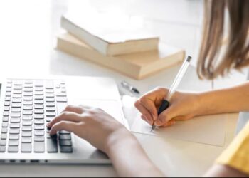 Pessoa preenchendo formulário de inscrição em curso gratuito no notebook.