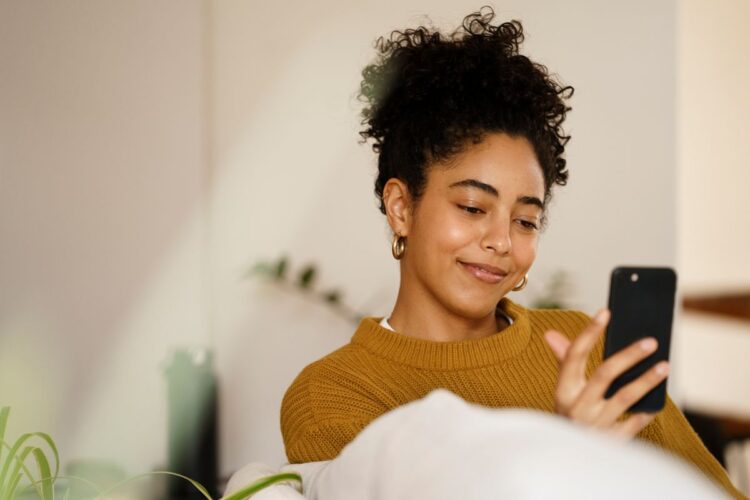 Mulher usando smartphone com expressão de atenção