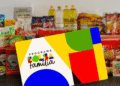 Cartão do Bolsa Família com alimentos ao fundo.