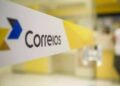 Faixa com logotipo dos Correios em agência de atendimento.