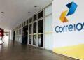 Fachada dos Correios com pessoas entrando na agência.