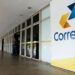 Fachada dos Correios com pessoas entrando na agência.