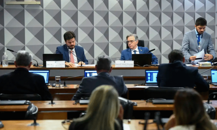 Membros da Comissão Mista do Congresso Nacional, reunidos em sessão de votação, com notebooks abertos e documentos sobre a mesa.