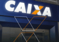 Fachada da Caixa Econômica Federal com destaque no logo iluminado.