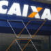 Fachada da Caixa Econômica Federal com destaque no logo iluminado.