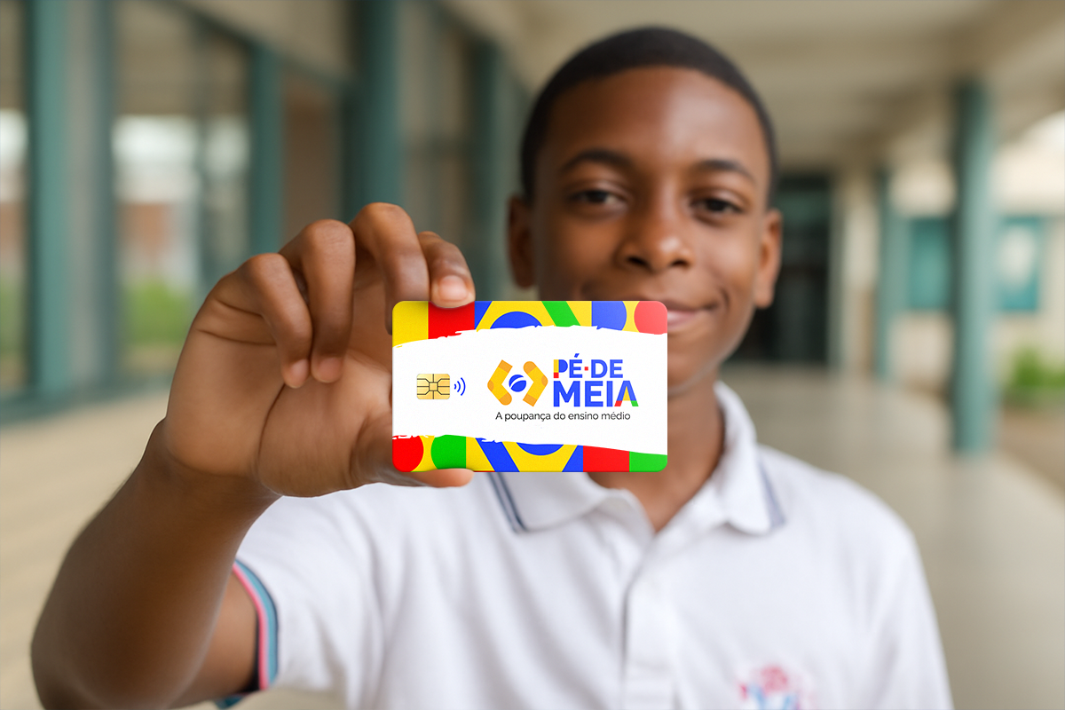 jovem sorrindo segurando um cartão do programa Pé de Meia