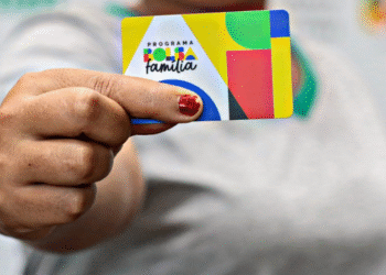 Cartão do Bolsa Família em destaque na mão de beneficiário.