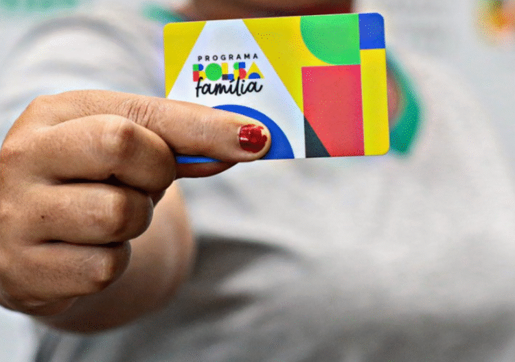 Cartão do Bolsa Família em destaque na mão de beneficiário.