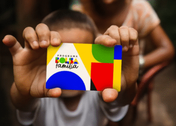 Bolsa Família de Setembro: criança segurando cartão colorido do programa.