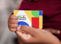 Mão segurando cartão do programa Bolsa Família.
