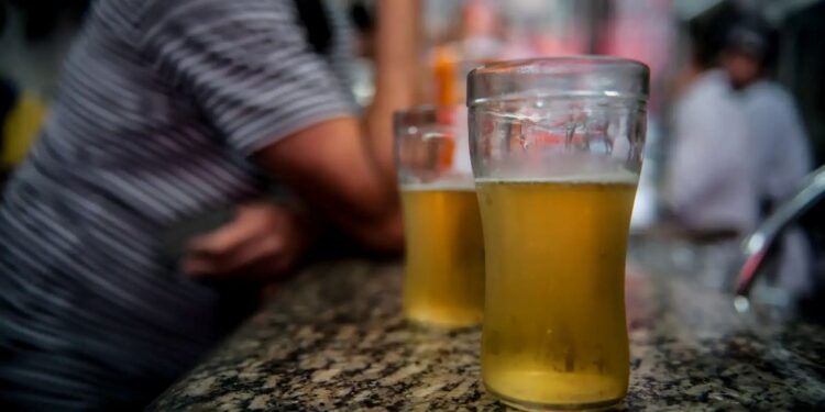 Copos de cerveja sobre balcão ilustram pauta sobre alcoolismo e INSS