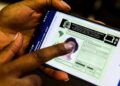 Pessoa acessando a versão digital da CNH em um celular, com dedo apontando para a tela