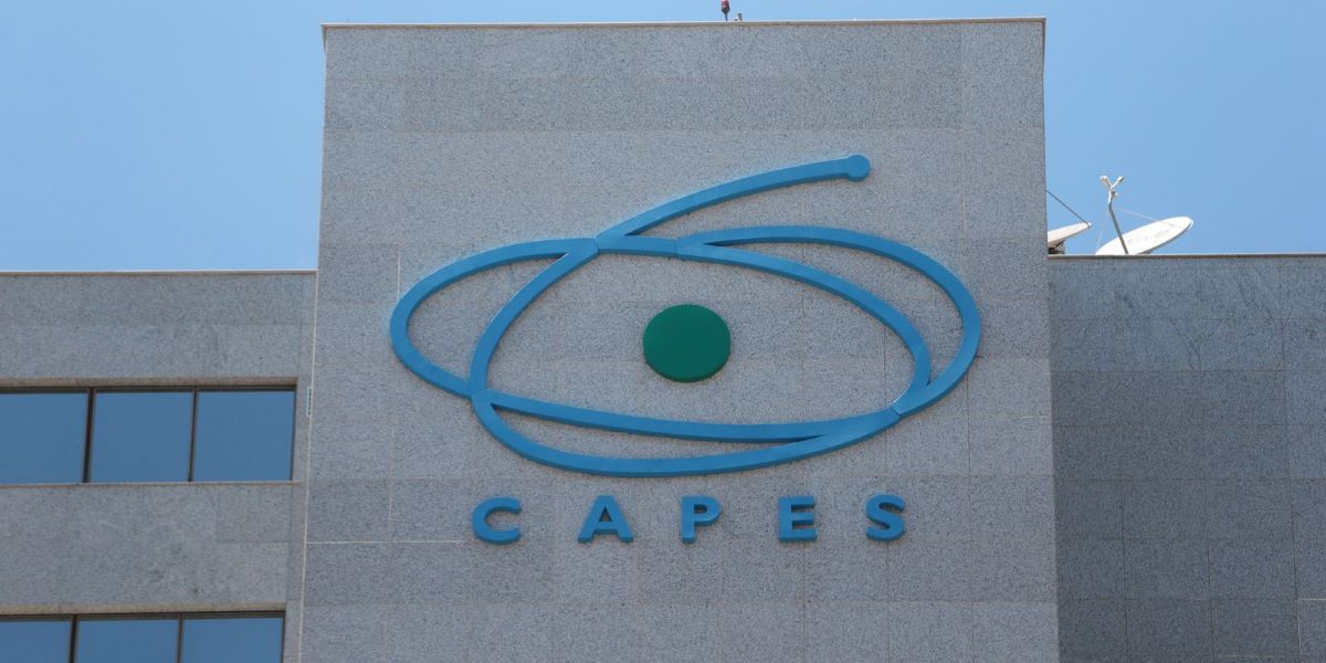 Logotipo da CAPES em destaque na fachada da sede, com céu azul ao fundo