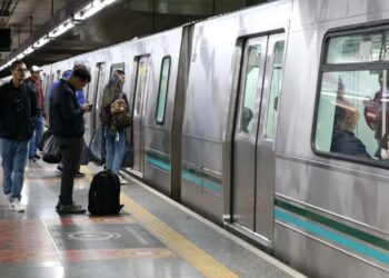 Passageiros aguardando o metrô em estação do estado, destacando a facilidade de emissão de carteira de identidade no local.