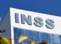 Prédio do INSS com placa em azul e branco sob céu claro, representando o Instituto Nacional do Seguro Social.