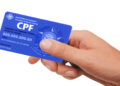 Mão de uma pessoa segurando um cartão de CPF azul com a inscrição ‘Cadastro de Pessoas Físicas’, simbolizando o golpe no CPF.