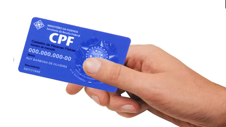 Mão de uma pessoa segurando um cartão de CPF azul com a inscrição ‘Cadastro de Pessoas Físicas’, simbolizando o golpe no CPF.