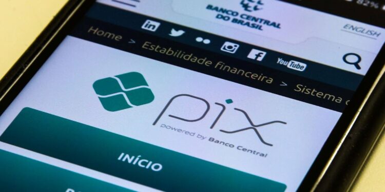 Tela de celular exibindo o logo oficial do Pix "powered by Banco Central" no site da instituição, simbolizando a notícia sobre o adiamento do lançamento do Pix Parcelado por questões de segurança contra fraudes e golpes milionários.