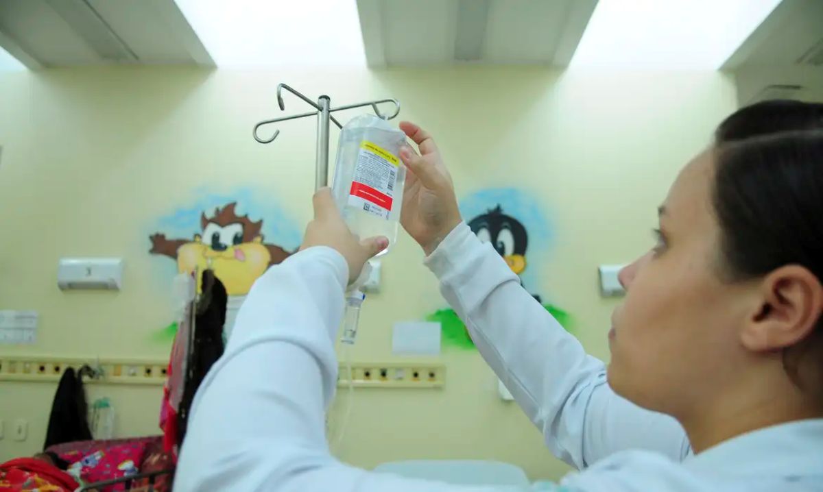 Profissional de enfermagem ajustando medicamento intravenoso em hospital