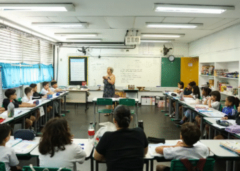 Uma professora, em uma sala de aula, dando uma palestra para seus alunos, simbolizando a importância da educação e do trabalho docente.