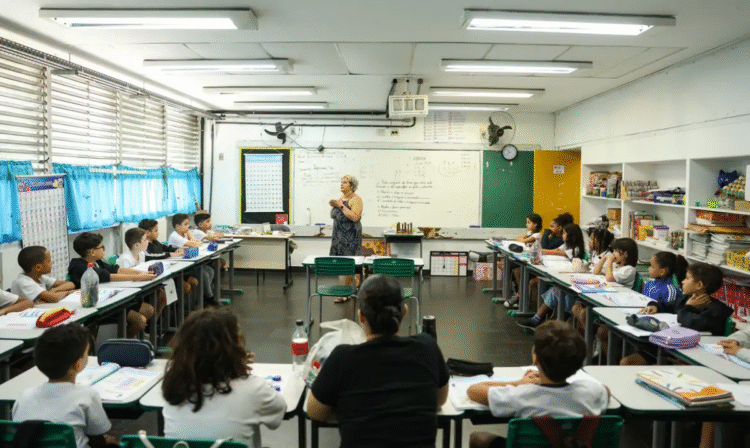 Uma professora, em uma sala de aula, dando uma palestra para seus alunos, simbolizando a importância da educação e do trabalho docente.