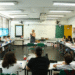 Uma professora, em uma sala de aula, dando uma palestra para seus alunos, simbolizando a importância da educação e do trabalho docente.