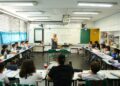 Professora em sala de aula com alunos do ensino fundamental.