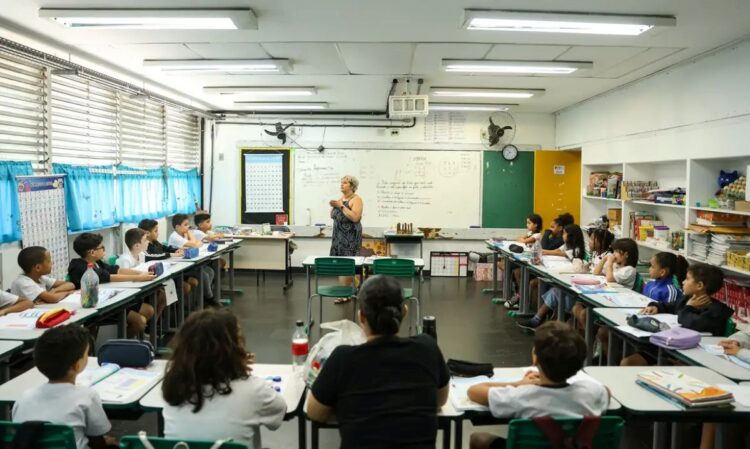 Professora em sala de aula com alunos do ensino fundamental.