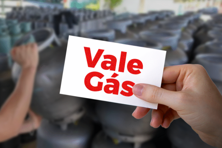 Cartão do Vale-Gás segurado por uma mão com botijões ao fundo