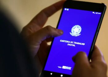 Pessoa usando o celular para acessar a Carteira de Trabalho Digital, plataforma para migração de contratos de empréstimos consignados, CLT.