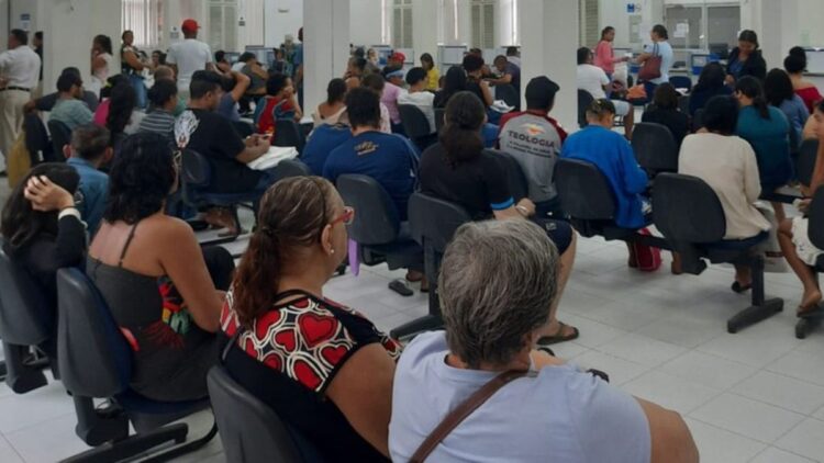 Pessoas sentadas em cadeiras em uma sala de espera do INSS, simbolizando a grande procura pelas 4.500 vagas oferecidas no mutirão de outubro de 2025.