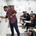 Professor explicando conteúdo na lousa em sala de aula, com alunos atentos