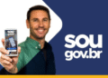Homem sorrindo enquanto segura um celular mostrando a tela do app SouGov.br.