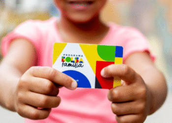 Criança segurando cartão do Programa Bolsa Família com design colorido.
