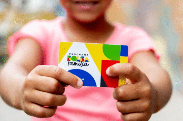 Criança segurando cartão do Programa Bolsa Família com design colorido.